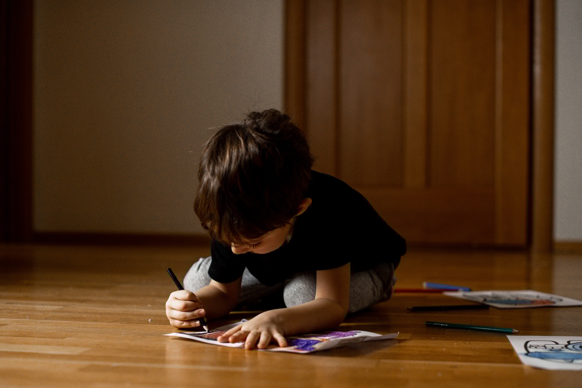A little boy 5 years old draws a drawing with colored pencils