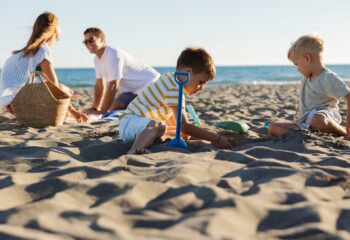 Family enjoying summer vacations playing on the beach