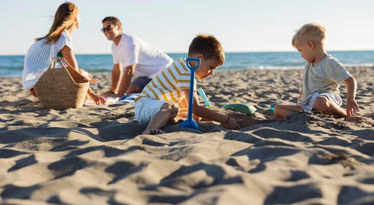 Family enjoying summer vacations playing on the beach