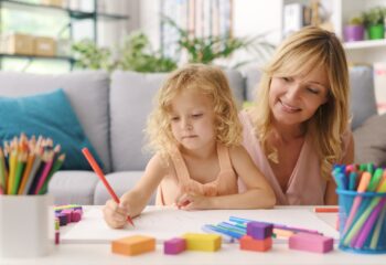Girl and mother drawing together at home