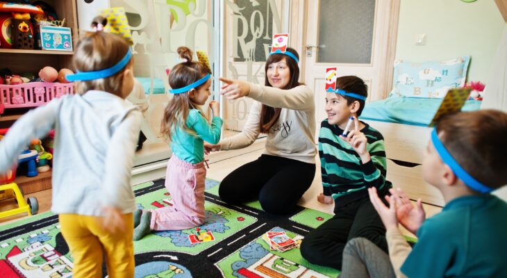 Happy family with four kids playing game guess who while having fun at home.