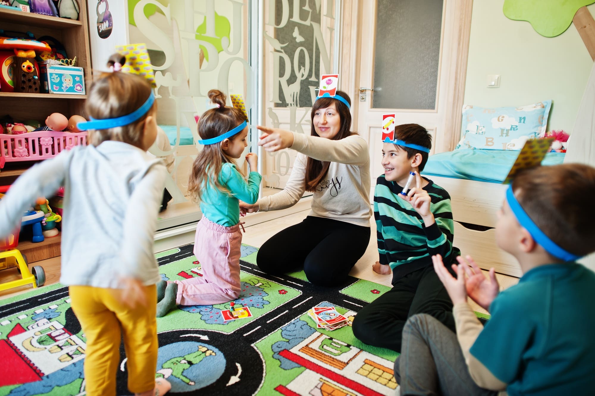 Happy family with four kids playing game guess who while having fun at home.