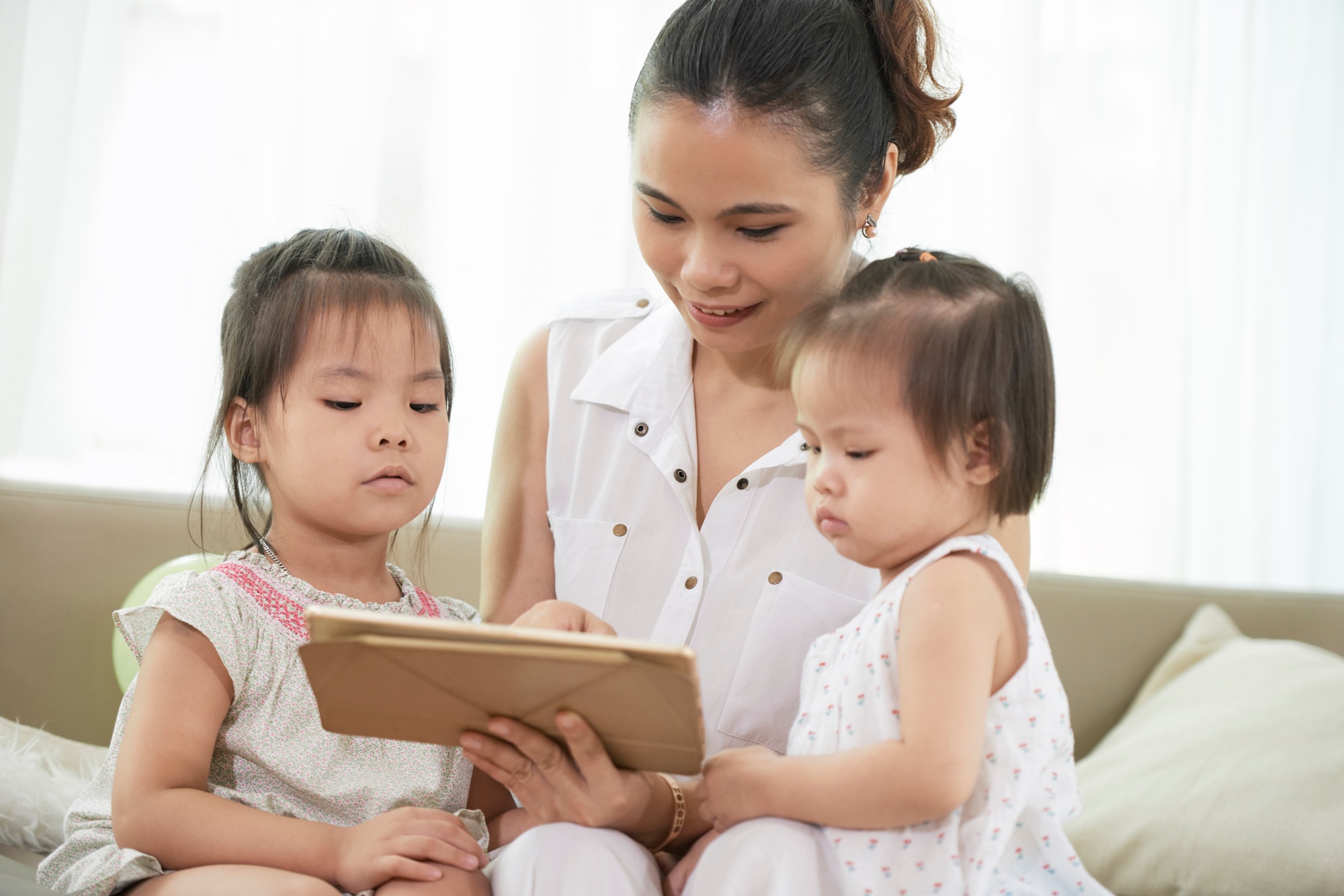 Mother Showing Game to Daughters