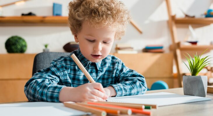 selective focus of kid drawing at desk