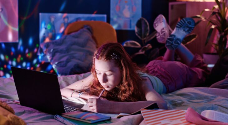 Teen Girl Doing Homework Late In Evening