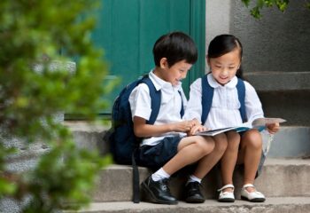 Two school children studying outside