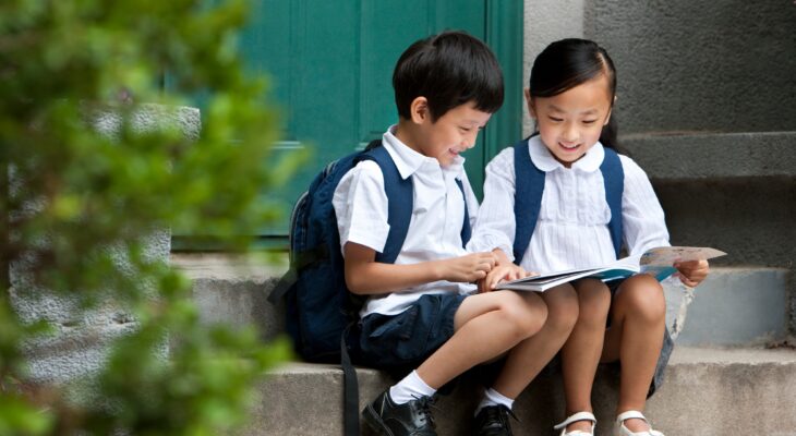 Two school children studying outside