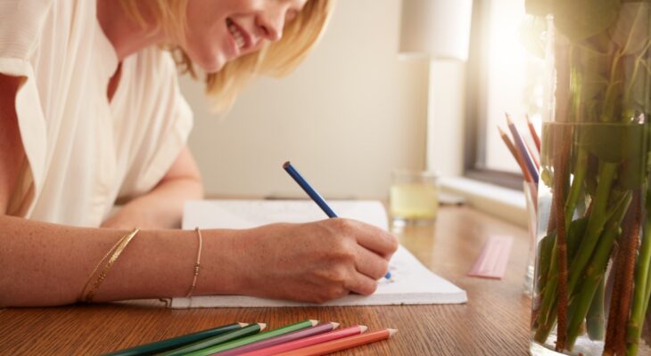 Woman coloring an adult coloring book with pencils