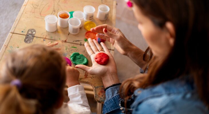 Mother and daughter playing with modeling clay at home
