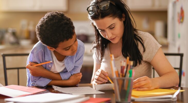 Woman Assisting Son In Doing Homework